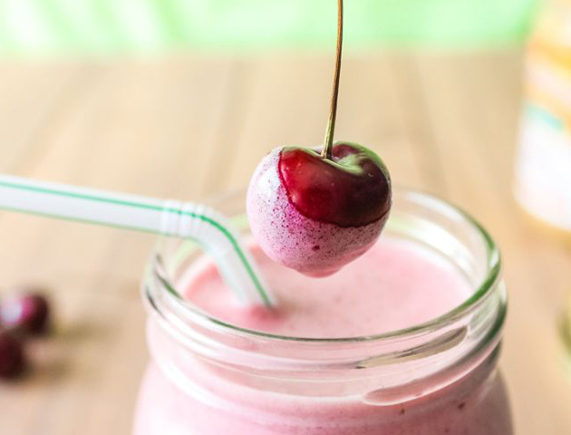 Cherry dipped into smoothie