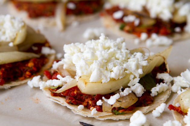 Mini pizzas with fennel and goat cheese on baking sheet